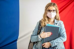 cara máscara proteccion vistiendo francés estudiante con libros de texto foto