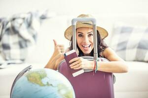 Happy woman shows thumbs up as travel restrictions ease and she can travel again, holding a passport and flight ticket photo