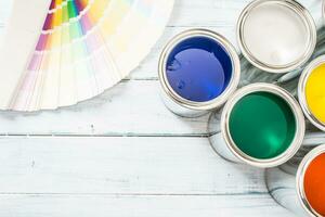 Top of view paint cans brushes and color palette on table photo