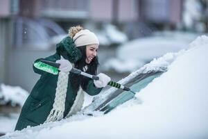 Hard work scraping windshields on the car from ice and snow during a cold winter photo