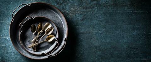 Antique trays with spoons on a rustic table - Top of view banner with copyspace photo