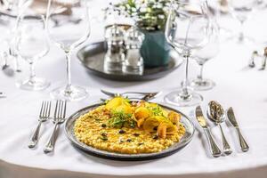 Creatively cooked pumpkin risotto served on a ceremonially prepared table in the hotel restaurant photo