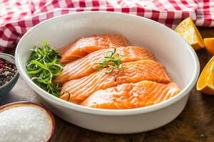 Raw salmon fillets with herbs in a baking dish photo