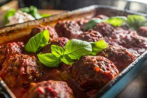 Delisious italian meal meat beef balls with basil in vintage roaster pan. photo