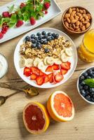 Healthy breakfast served with plate of yogurt muesli blueberries strawberries and banana. photo