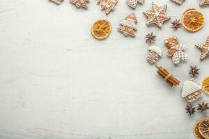 Cinnamon star anise gingerbread and dry orange on white concrete background. Top of view photo