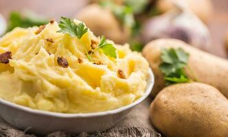 Mashed potatoes in bowl decorated with parsley herbs. photo