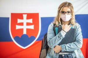 Face mask wearing student teenager with Slovak flag in the background photo