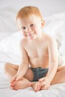 Habby young smilling child boy in white bed photo