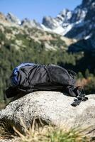 Abandoned hiking rucksack placed on a rock in the mountains photo