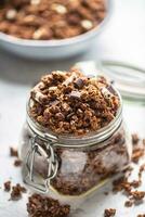 Jar of muesli with dark and milk cocolate pieces - closeup photo