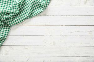 Green checkered kitchen tablecloth on wooden table photo