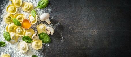 Raw ravioli with flour egg musrooms and and spinach - Top of view. Italian or mediterranean healthy cuisine photo