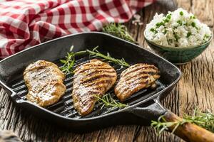 Grilled chicken breast on grilled pan with rice and green peas photo