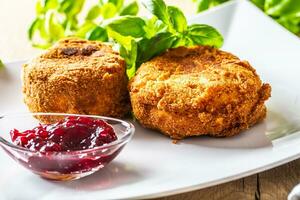 Fried camembert or brie cheese with cranberry jam and basil photo