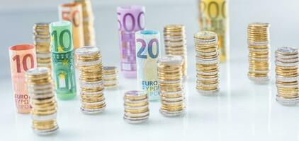 Rolled euro banknotes and coins towers stacked in other positions photo