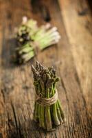 Fresh green asparagus on old oak table photo
