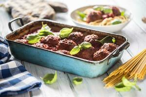 Delisious italian meal meat beef balls with pasta spaghetti and basil in vintage roaster pan photo