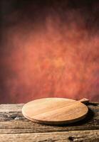 Empty pizza round board  old wooden table and colour blurred background photo