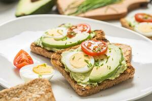 sano desayuno desde tostadas con aguacate untado guacamole huevo tomate y cebollín. foto