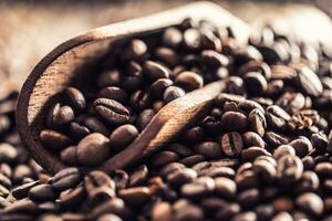 Wooden scoop full of coffee beans on old oak table photo