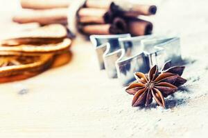 Star anise cookie cutter cinnamon and flour on baking board. Christmas baking utensil and holiday concept photo