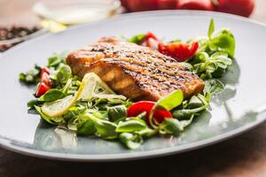 Grilled  salmon fillet with salad tomatoes and sesame photo