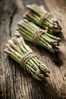 Fresh green asparagus on old oak table photo