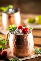 Moscow Berry Mule highball vodka cocktail is a long drink with fresh lime juice, ginger beer and berries photo