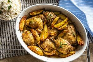 Chicken legs roasted with american potatoes in baking dish photo