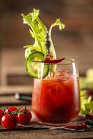 Classic bloody mary or virgin mary vodka cocktail in a cup with as a hangover drink in a rustic envrionment photo
