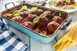 Delisious italian meal meat beef balls with pasta spaghetti and basil in vintage roaster pan photo