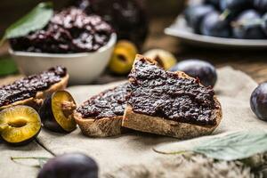 Breakfast from homemade plum jam bread and ripe plums. photo