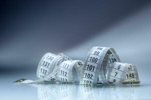 Curved measuring tape. Measuring tape of the tailor. Closeup view of white measuring tape photo