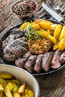 Grilled beef Rib Eye steak with garlic american potatoes rosemary salt and spices photo