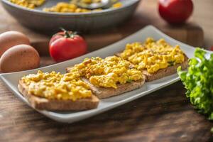 Scrambled eggs on toasts served on a plate photo