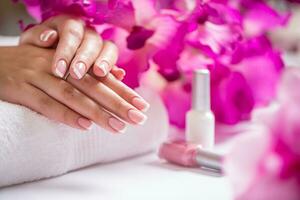 Closeup shot of beautiful female dands with nails of france manicure. Manicure and spa concept photo