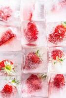 Three rows of ice cubes with strawberries - Top of view photo