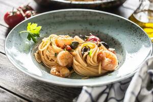 pasta espaguetis en plato y pan con camarón tomate salsa Toatoes y hierbas. italiano o Mediterráneo cocina foto