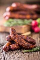 Sausages. Smoked Sausages. Chorizo sausages with vegetable rosemary spices and kitchen utensil. photo