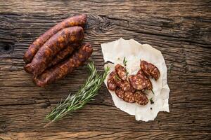 Sausages. Smoked Sausages. Chorizo sausages with vegetable rosemary spices and kitchen utensil. photo