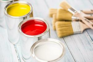 Close-up brushes lying on multicolored paint cans. photo