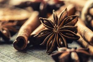 Detail of star anize and cinnamon sticks on a vintage wooden surface photo