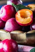 Plums. Fresh juicy plums in a bowl on a wooden or concrete board photo