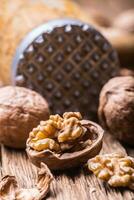 Walnut. Walnut kernels and whole walnuts on rustic old oak table photo