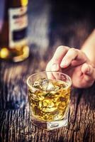 alcoholismo.mano alcohólico y bebida el destilar whisky brandy o coñac. foto