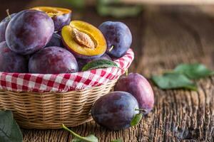 Plums. Fresh juicy plums in a bowl on a wooden or concrete board photo