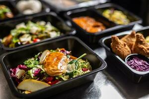 Plenty of open plastic containers containing delicious takeaway food ready for delivery photo