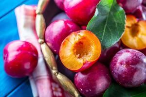 Plums. Fresh juicy plums in a bowl on a wooden or concrete board photo