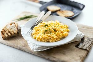 Plate of scrambled organic eggs served with bread toasted on a griddle pan photo